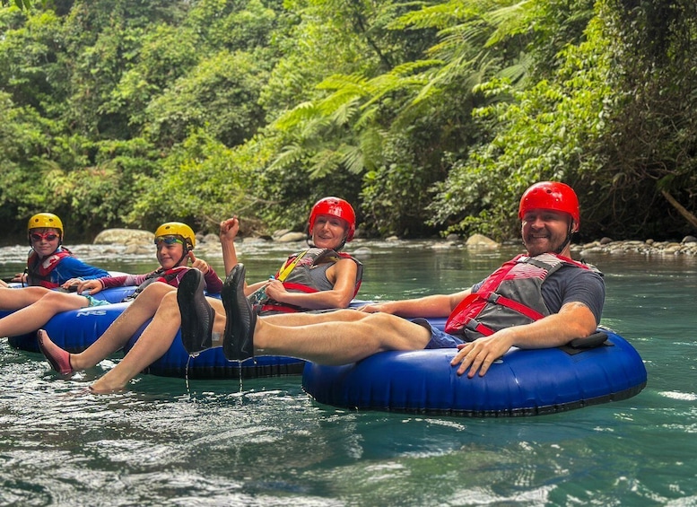 People on inflatable rafts in a river surrounded by greenery. 1
