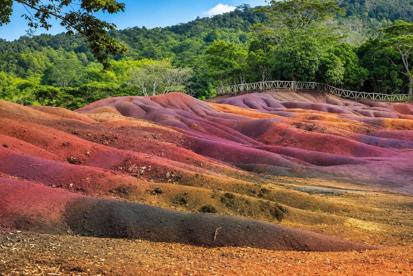 A landscape with colorful terraced hills and a wooden fence. 1
