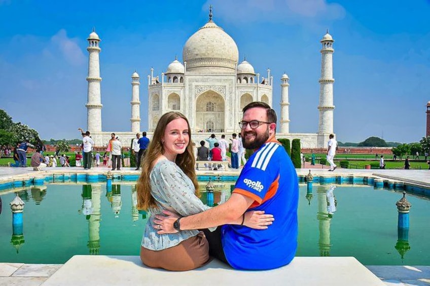 Een stel genietend van het zwembad, met het Taj Mahal op de achtergrond. 1