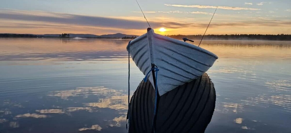A boat with a white sail on calm water during sunset. 5