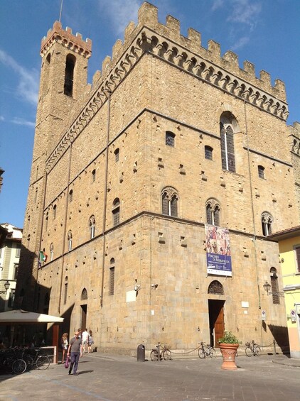 A historic stone building with a tower and arched windows. 2