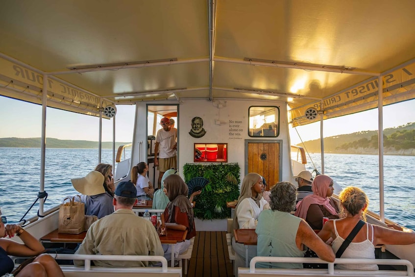 A boat with people seated and standing, a portrait, and a quote on the wall. 5