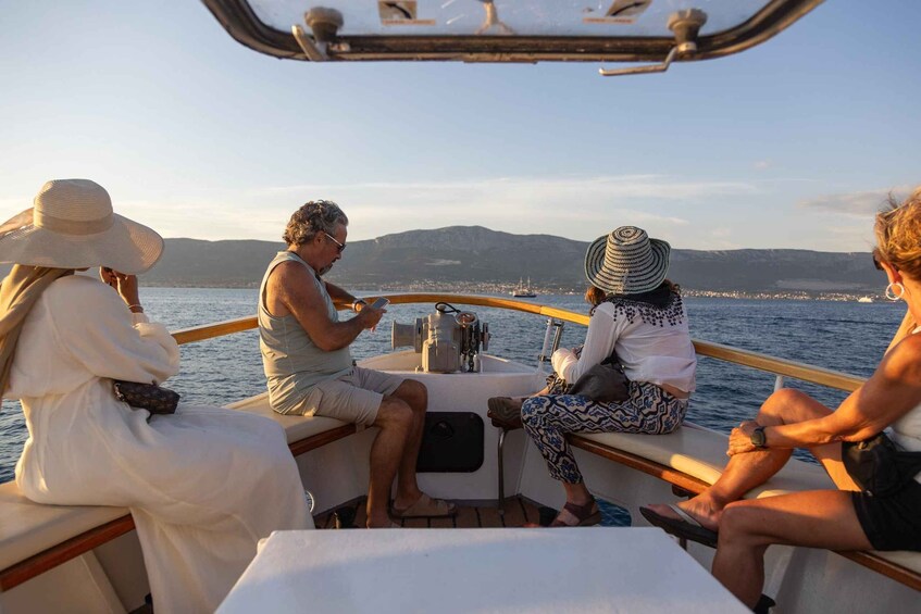 A group of people on a boat with a view of the sea and distant land. 5