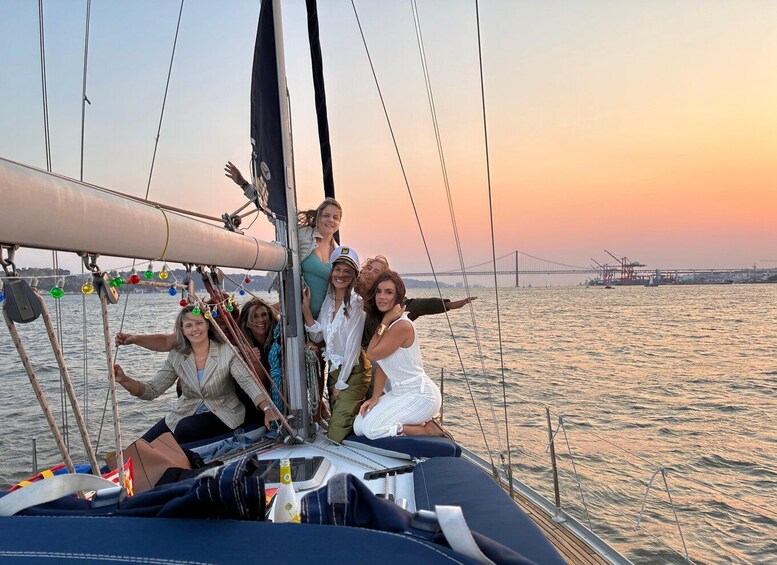 A group of people on a sailboat with a bridge in the background. 1