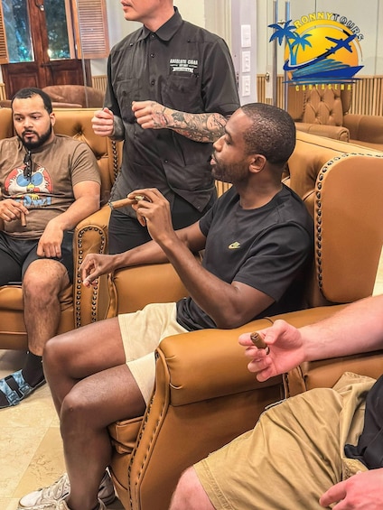 A group of men in a leather chair lounge, one holding a cigar. 4
