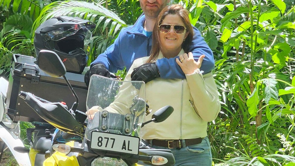 A person standing next to a motorcycle with a visible license plate. 2