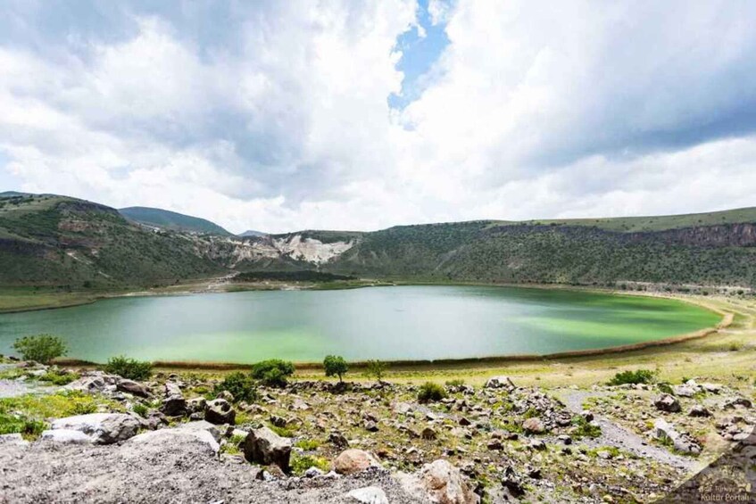 A lake surrounded by mountains with a cloudy sky. 3