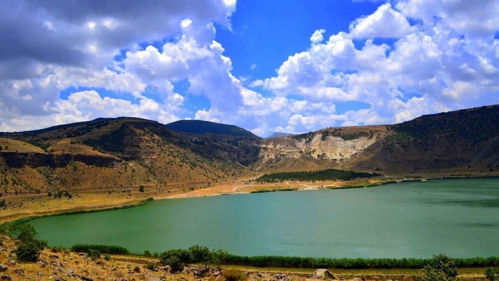 A lake surrounded by hills and a clear sky. 2