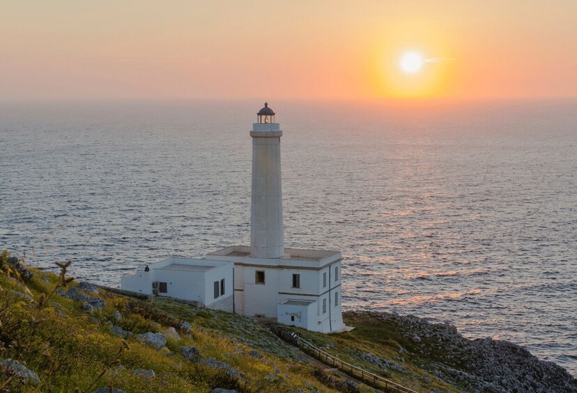 A lighthouse by the sea at sunset. 2