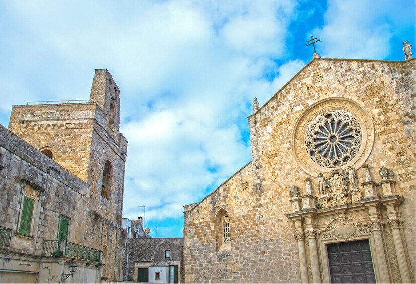 A historic stone building with a large circular window and a bell tower. 3