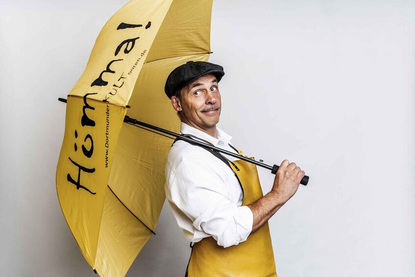 A person holding a yellow umbrella with black text. 1