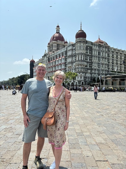 A man and woman standing in front of a historic building with ornate architecture. 5