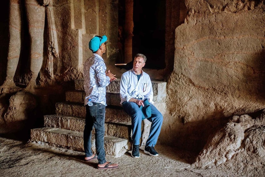 Two people in a cave with stone steps and columns. 4