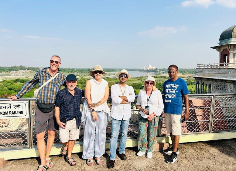 A group of people standing on a bridge with a view of a large domed structure in the background. 5