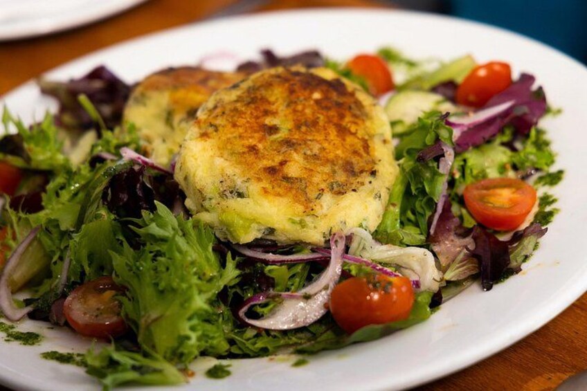 Pictured here is our vegan option which is a modern twist on a traditional Irish dish, "colcannon" cakes served on a bed of seasonal salad from our kitchen garden. 2