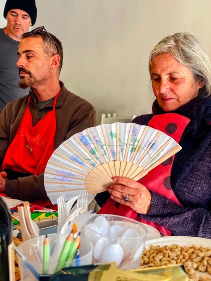 A person holding a fan with colorful designs. 5