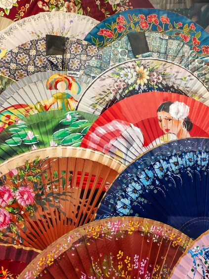 A collection of colorful fans with intricate floral and geometric patterns. 4