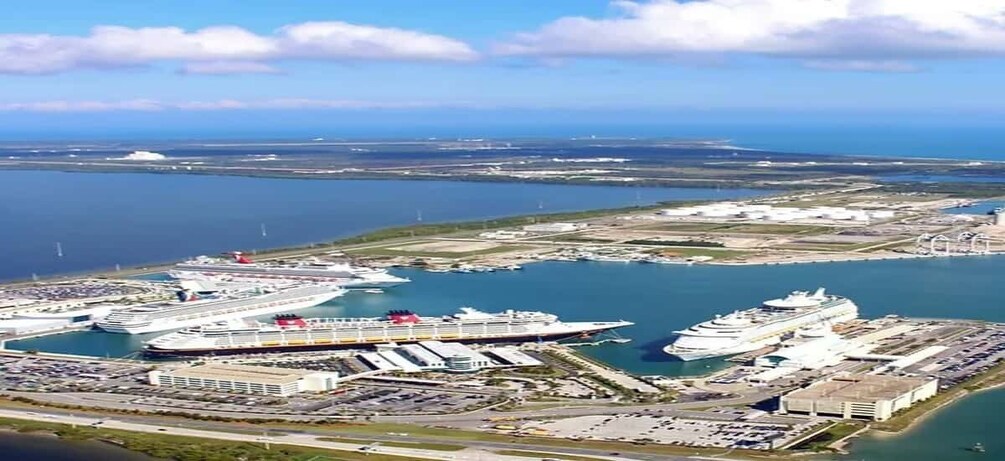A large cruise ship port with multiple ships docked and a busy terminal area. 2