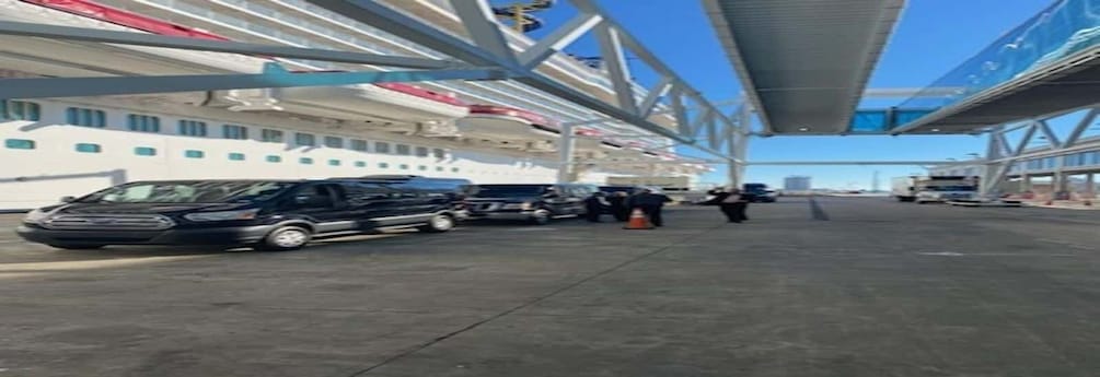 A cruise ship docked at a port with vehicles and personnel on the deck. 3