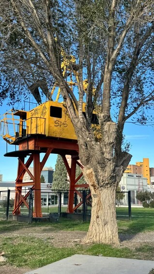 A tree with a yellow structure on its branches, a metal framework, and a clear blue sky. 3