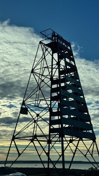 A tall, skeletal metal structure against a cloudy sky. 4
