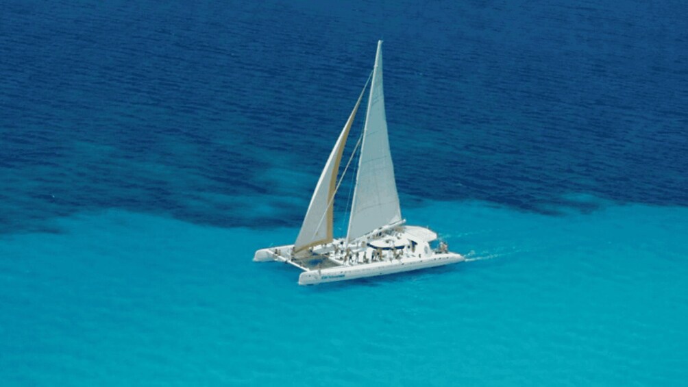 A white sailboat with two sails on a turquoise sea. 2