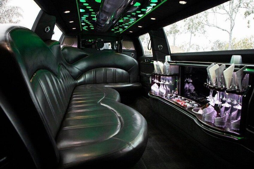 A luxurious car interior with leather seats and a minibar. 4