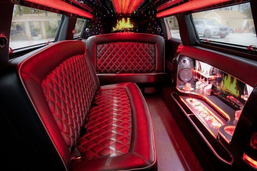 A luxury vehicle interior with red leather seats and ambient lighting. 5