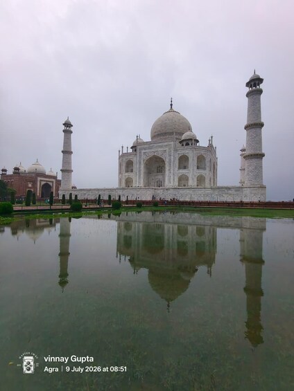 The Taj Mahal with its reflection in the water, surrounded by greenery. 2