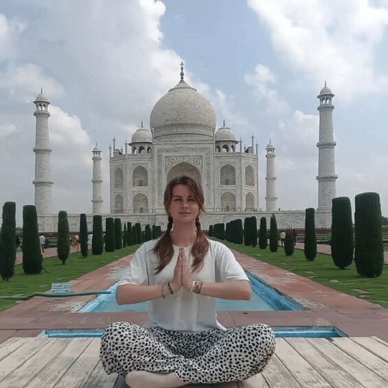 A person in a meditative pose with the Taj Mahal in the background. 3