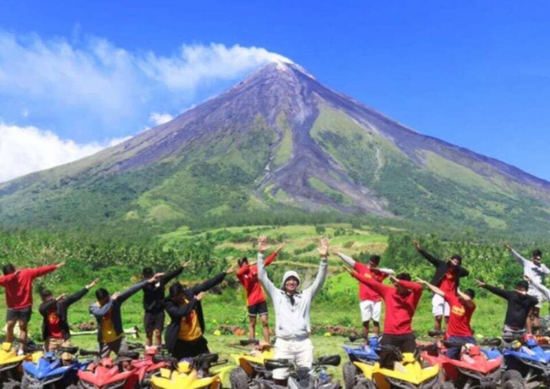 A group of people on quad bikes in front of a volcano. 3