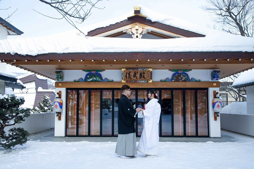 A traditional building with a snow-covered roof and a sign with Japanese characters. 3