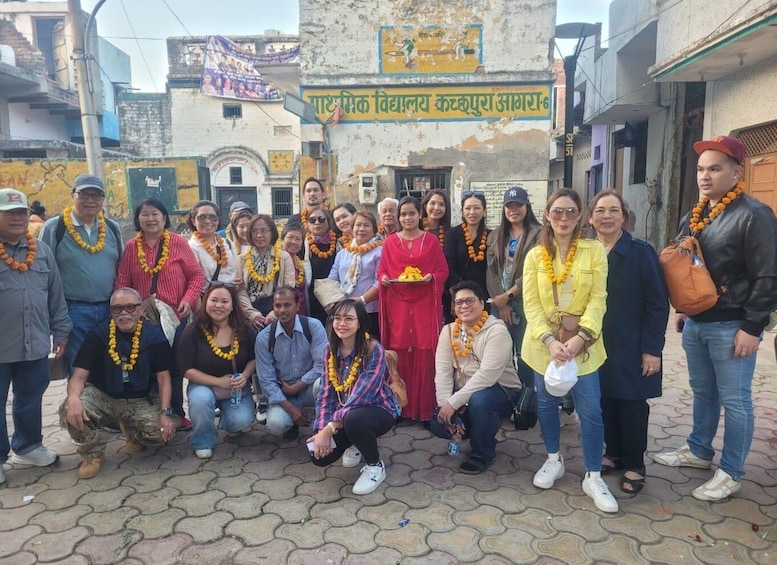 Un grupo de personas posando frente a un edificio con un letrero en un idioma local. 3