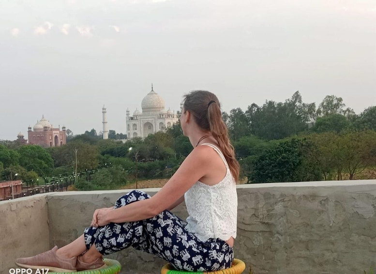 Una persona sentada en un borde de concreto mirando un edificio histórico. 5