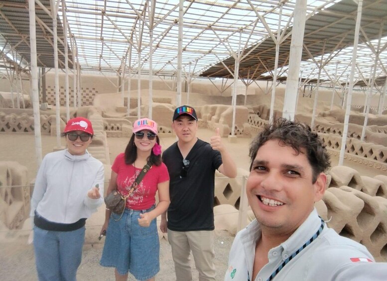 A group of people in a covered area with a metal framework and sandbags. 1