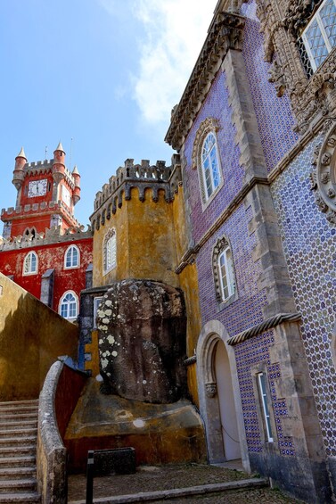 A historic building with a clock tower, ornate windows, and a tiled facade. 5