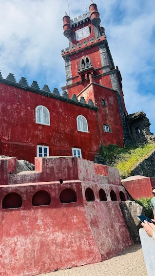 A castle with red walls, a clock tower, and arched windows. 2