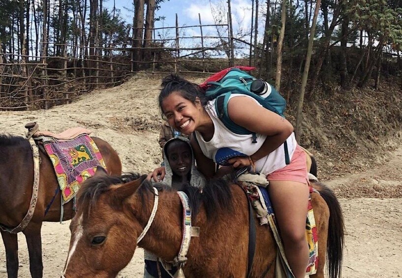 A person riding a horse with a saddle and a colorful blanket. 1
