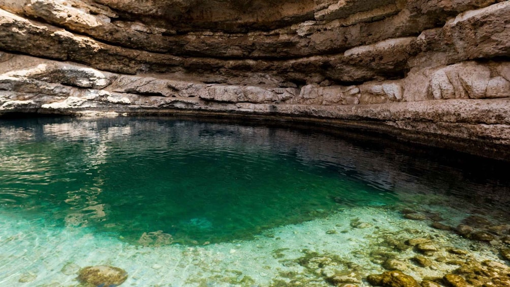 A clear, natural pool surrounded by rocky walls. 3