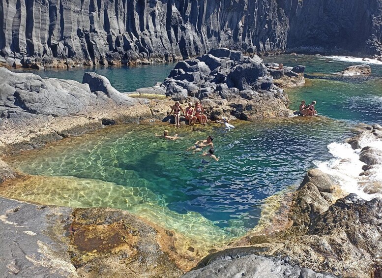 A natural pool surrounded by rocky cliffs. 3