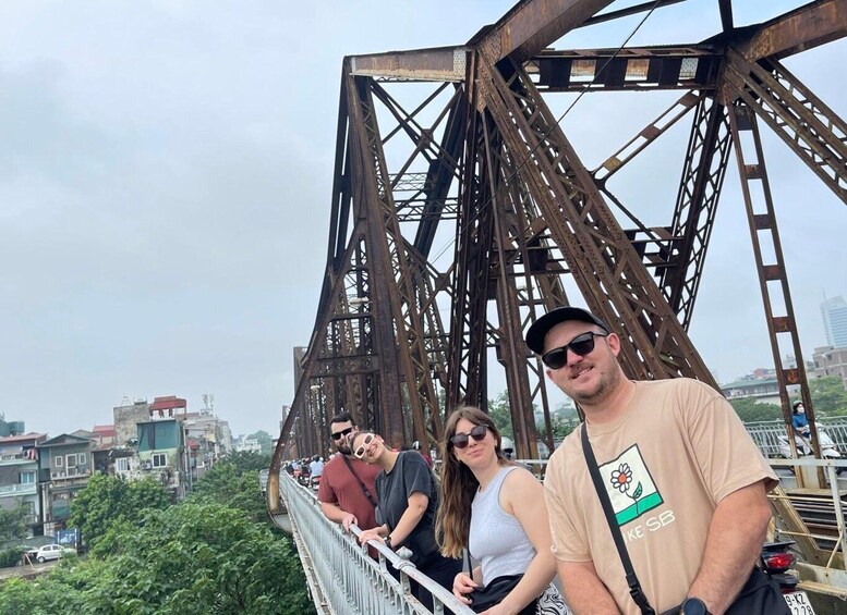 A group of people on a bridge with a complex metal structure. 3