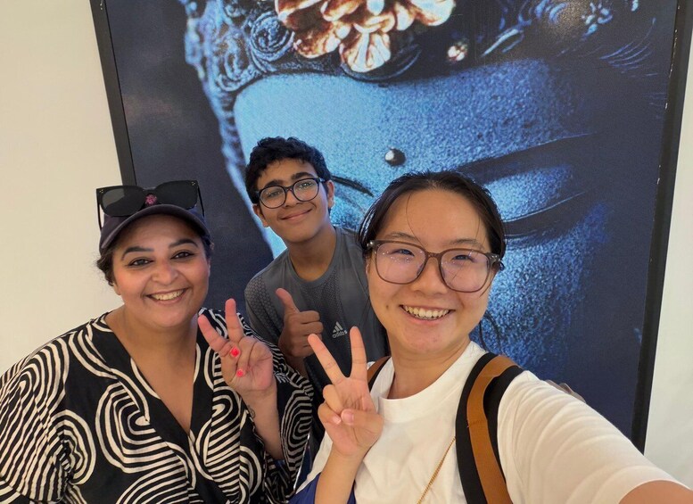 Three people taking a selfie with a large digital display in the background. 5