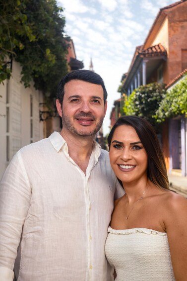 A couple standing in a narrow street with buildings on either side. 4