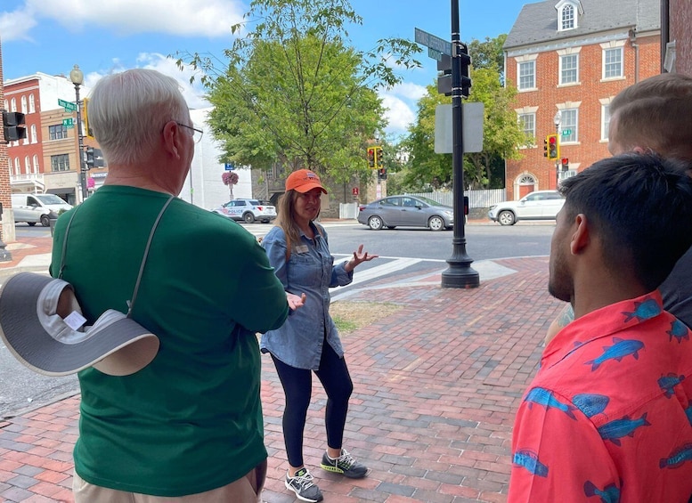 Three people standing on a sidewalk near a street intersection. 4