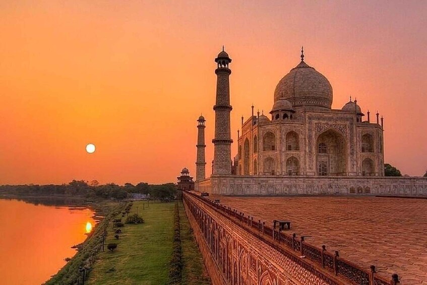 Taj Mahal ved solnedgang med månen synlig på himlen. 1