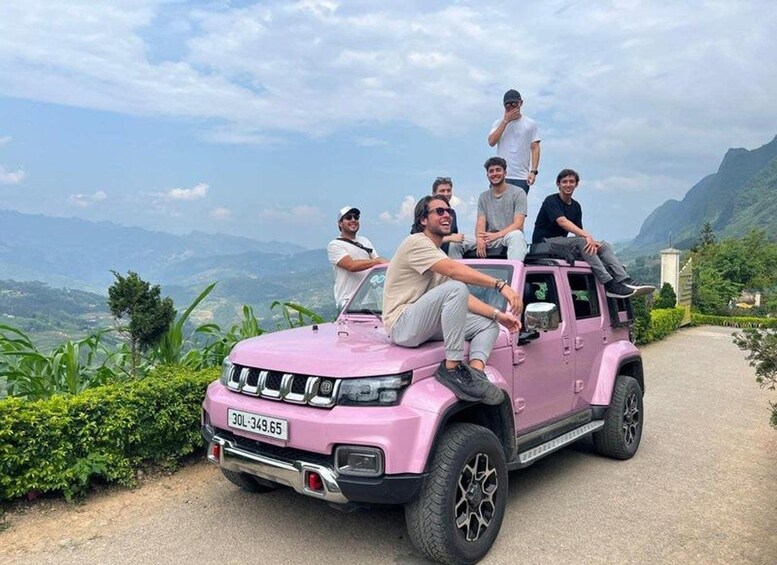 A pink SUV parked on a road with a mountainous landscape in the background. 1