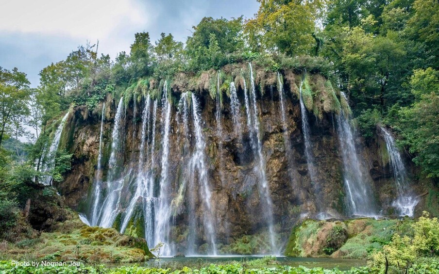 A multi-tiered waterfall surrounded by lush greenery. 4