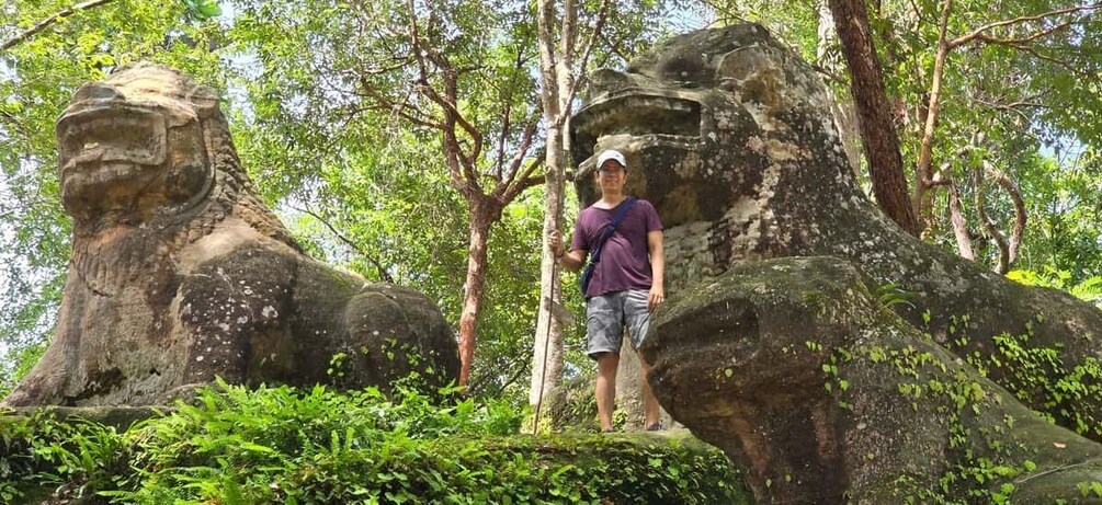 A person standing on a rock formation with a large stone face. 2