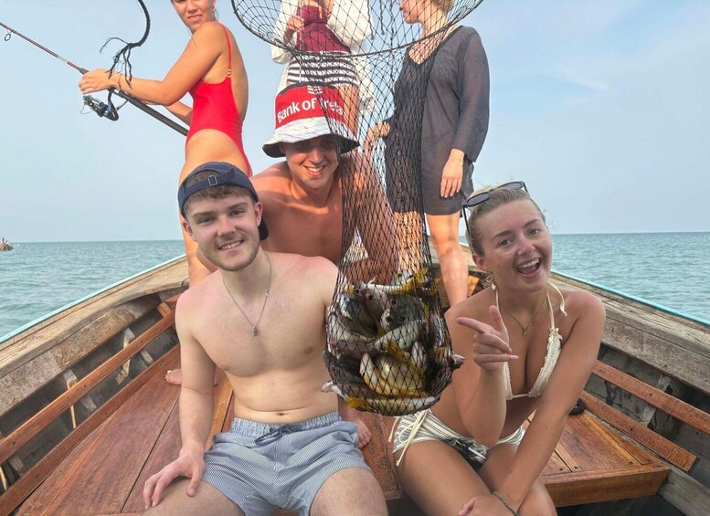 People on a wooden boat with a fishing net containing fish. 3