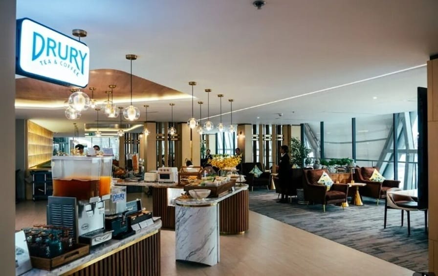 Un hall d’hôtel Drury moderne, doté d’un bar à café, d’un espace salon et de grandes fenêtres. 2